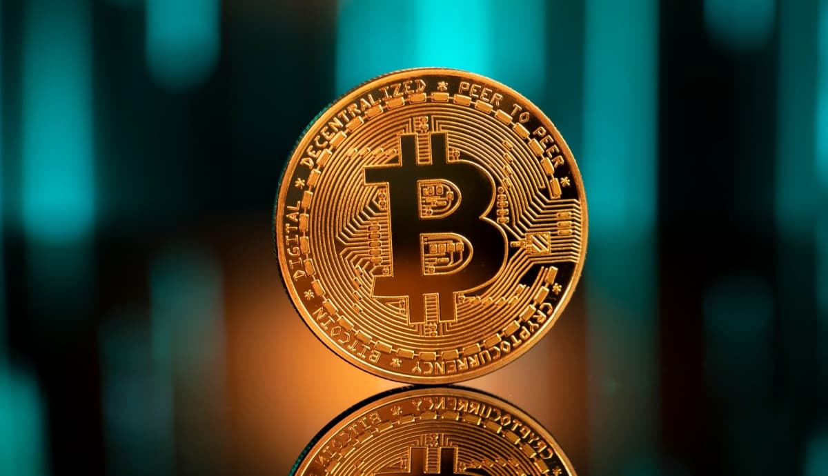 moeda dourada de bitcoin;ao fundo, luzes azuis